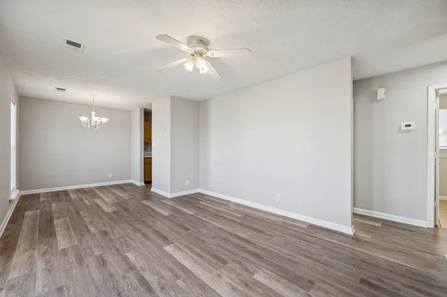 a view of an empty room with wooden floor
