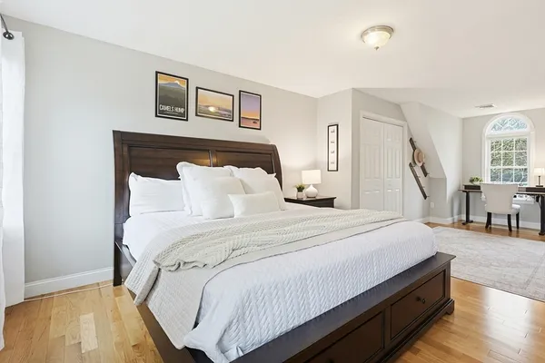 a spacious bedroom with a bed and a dresser next to a window