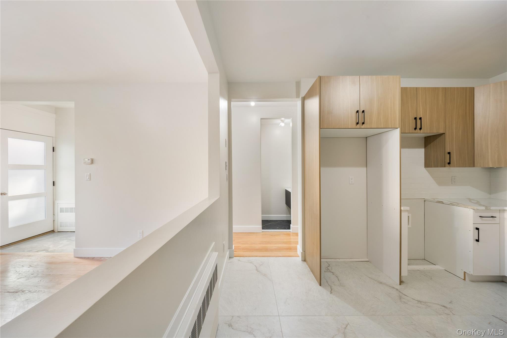 19 Lazer Court, Unit 102 Spring Valley, NY 10977 - Photo 18 of 31 Kitchen featuring modern cabinets, radiator heating unit, and light stone countertops