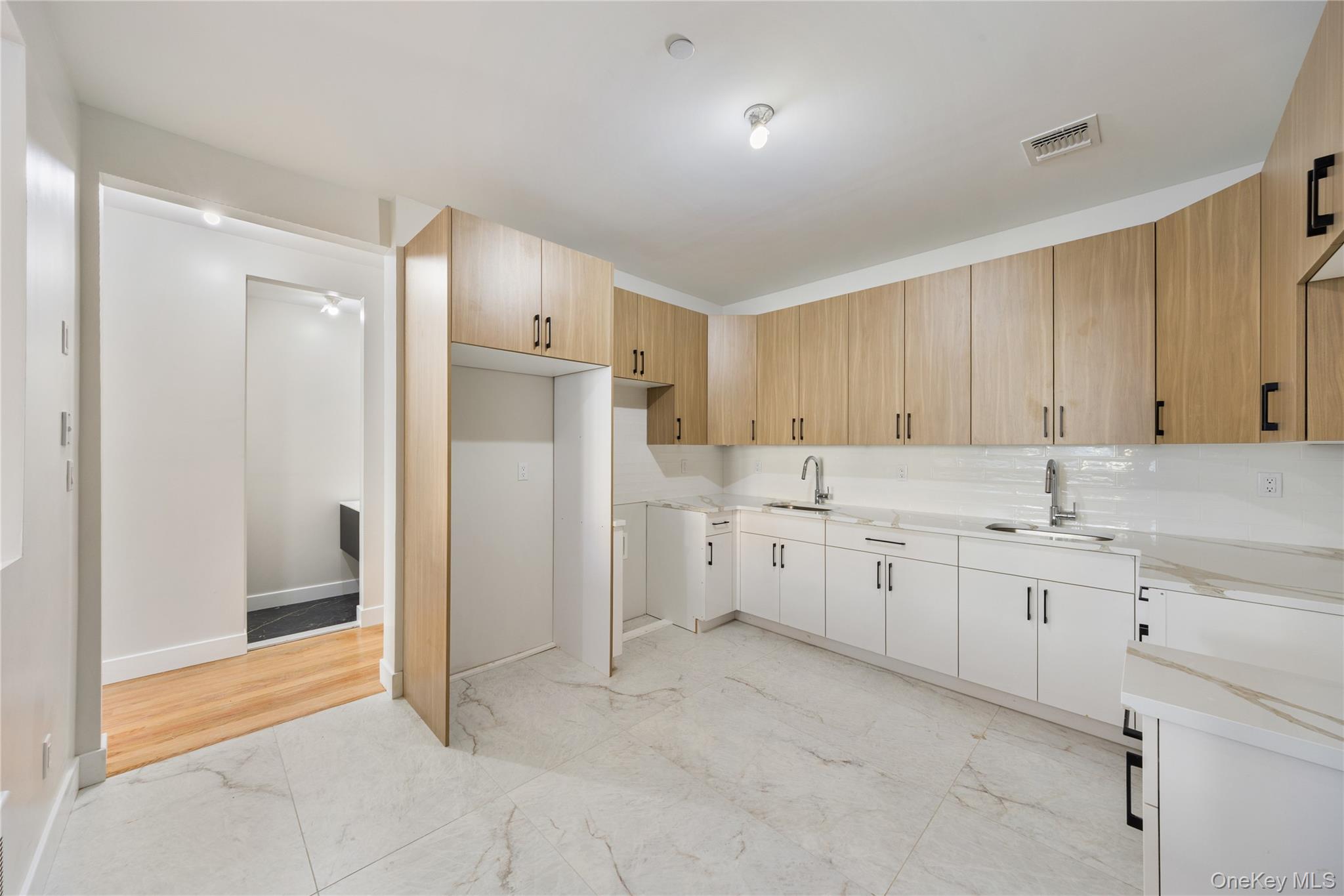 19 Lazer Court, Unit 102 Spring Valley, NY 10977 - Photo 19 of 31 Kitchen with modern cabinets, light stone countertops, and light marble finish floors