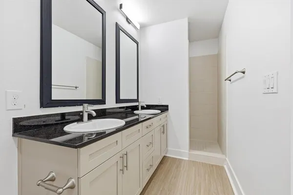 a bathroom with a granite countertop sink and a mirror