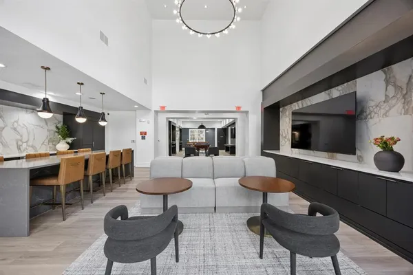 a living room with furniture a table and kitchen view