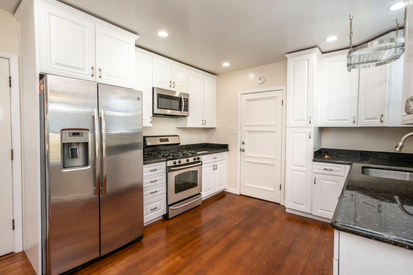540 Sylvan Avenue San Mateo, CA 94403 - Photo 10 of 23 a kitchen with cabinets stainless steel appliances and wooden floor