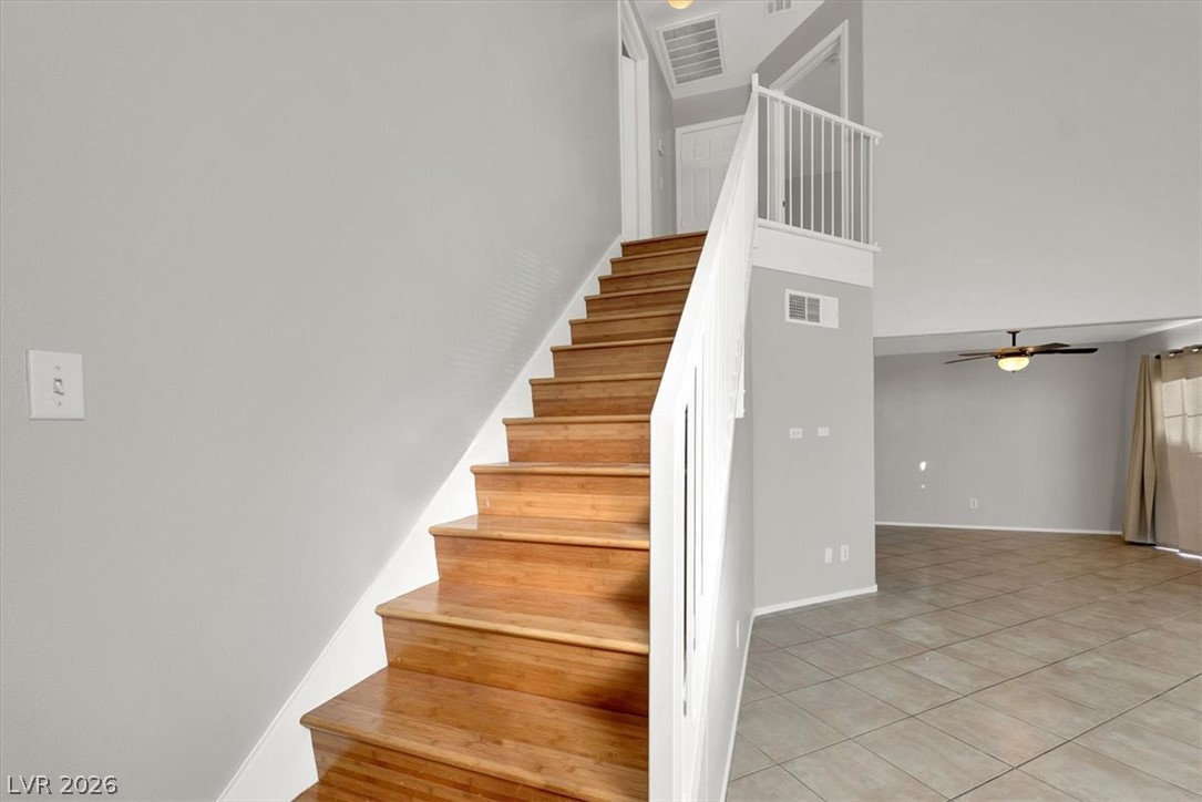 10148 Tree Bark Street Las Vegas, NV 89183 - Photo 19 of 37 Natural wood stairs ascend to an open-concept living space with lofty ceilings.