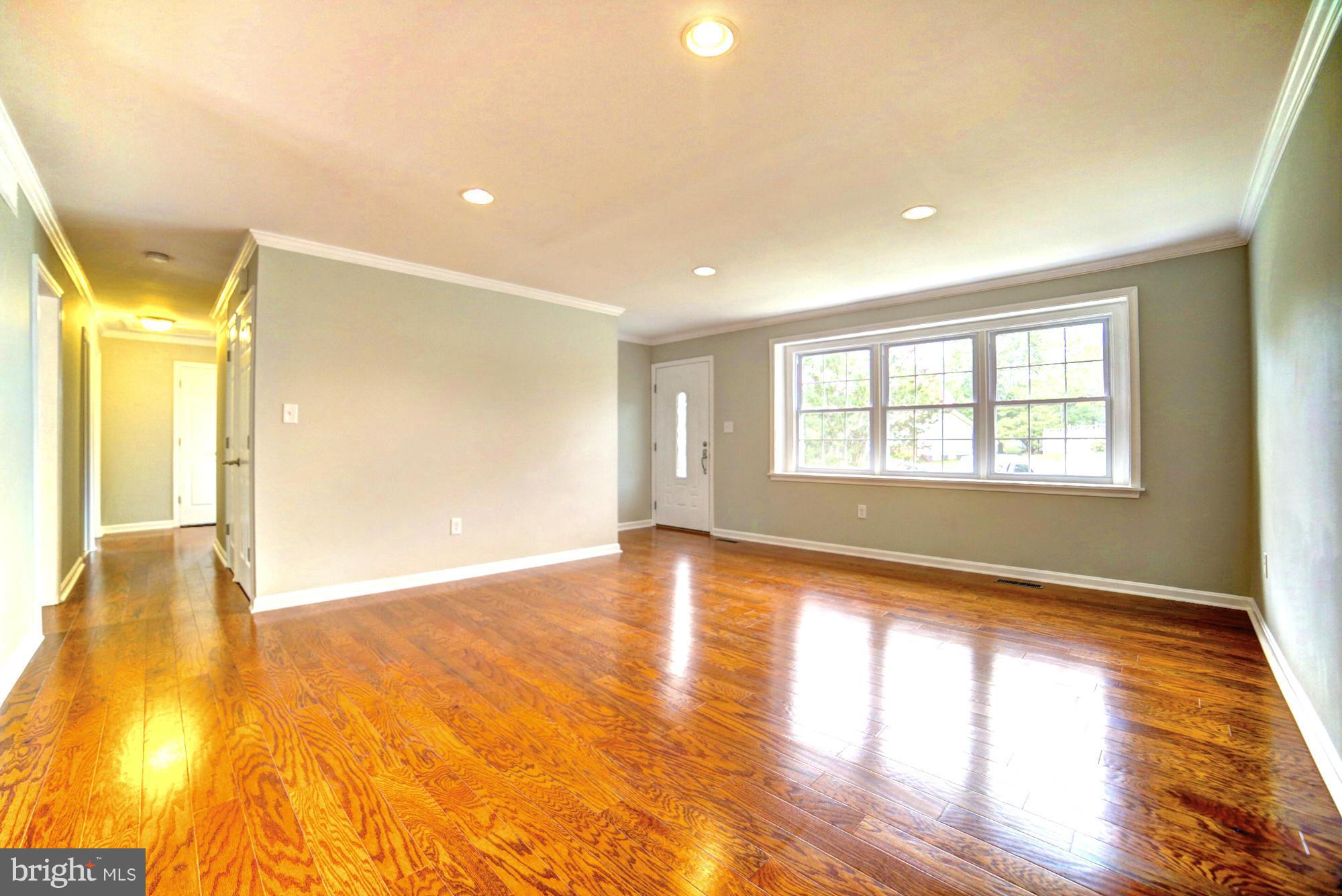 4021 Rouen Road Randallstown, MD 21133 - Photo 4 of 22 a view of an empty room with wooden floor and a window