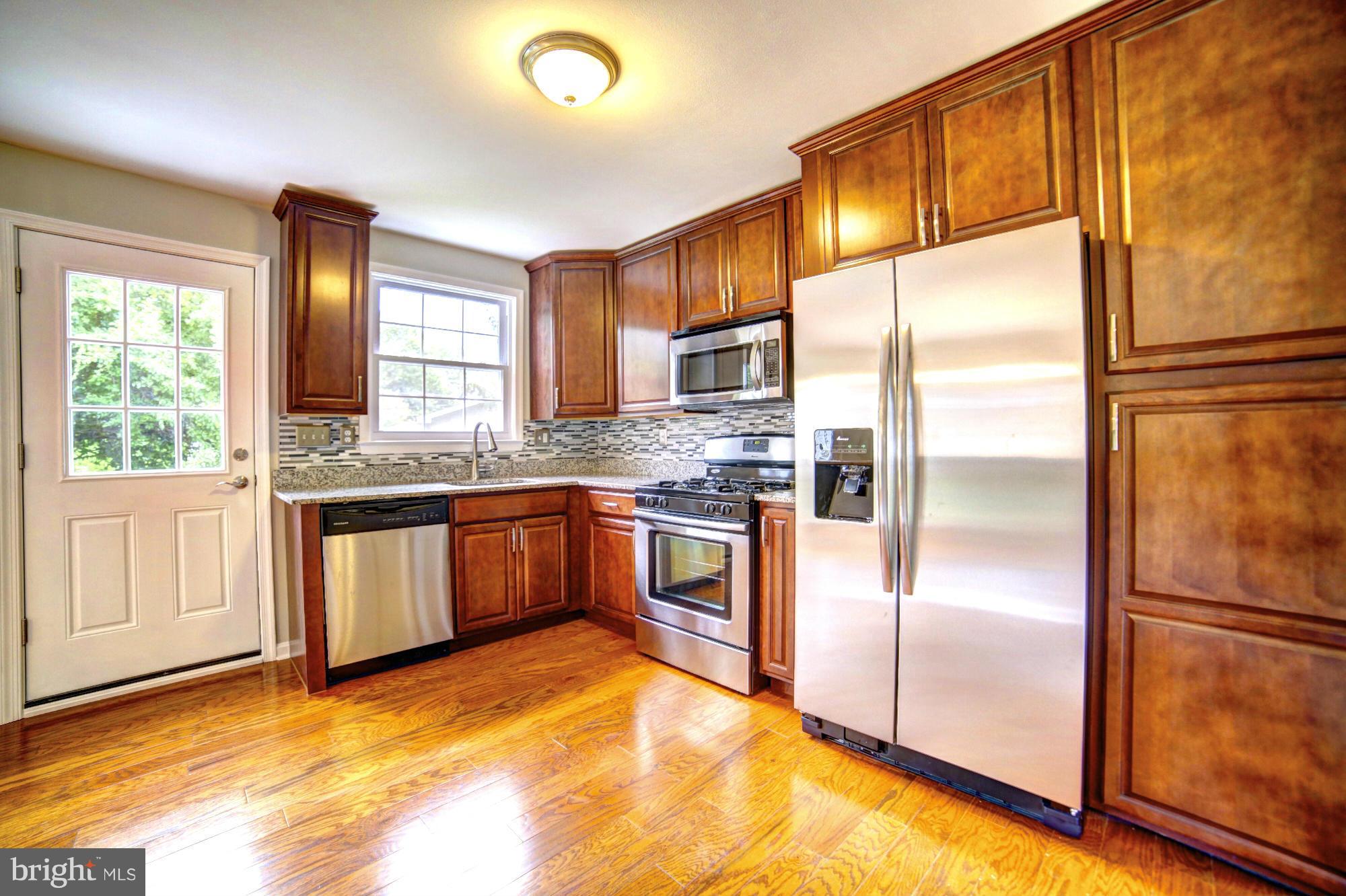 4021 Rouen Road Randallstown, MD 21133 - Photo 7 of 22 a kitchen with stainless steel appliances granite countertop a refrigerator a sink a stove and oven