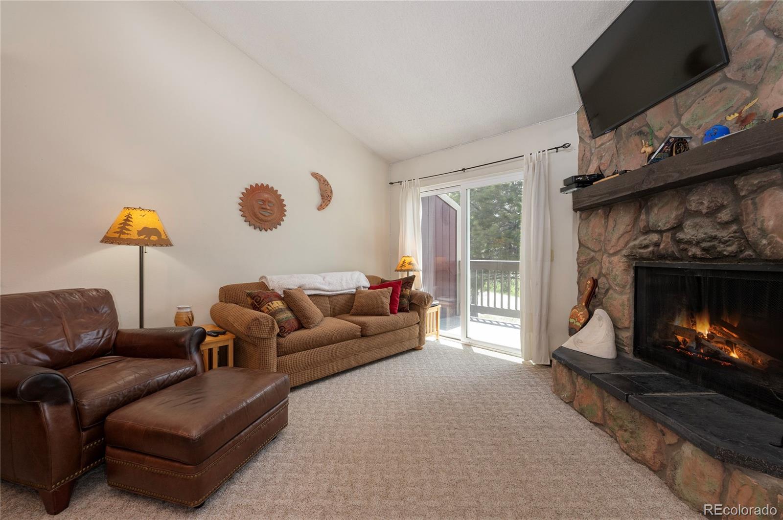 80 Gcr 838/e Meadow, Unit 2211 Fraser, CO 80442 - Photo 5 of 16 a living room with furniture a flat screen tv and a fireplace