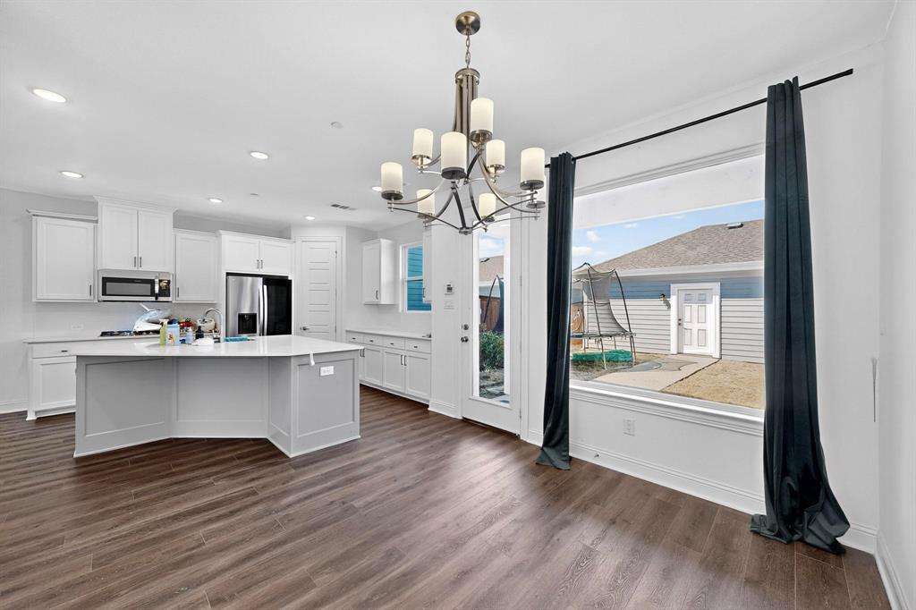 6629 Kort Street Rowlett, TX 75089 - Photo 12 of 39 a large white kitchen with a chandelier