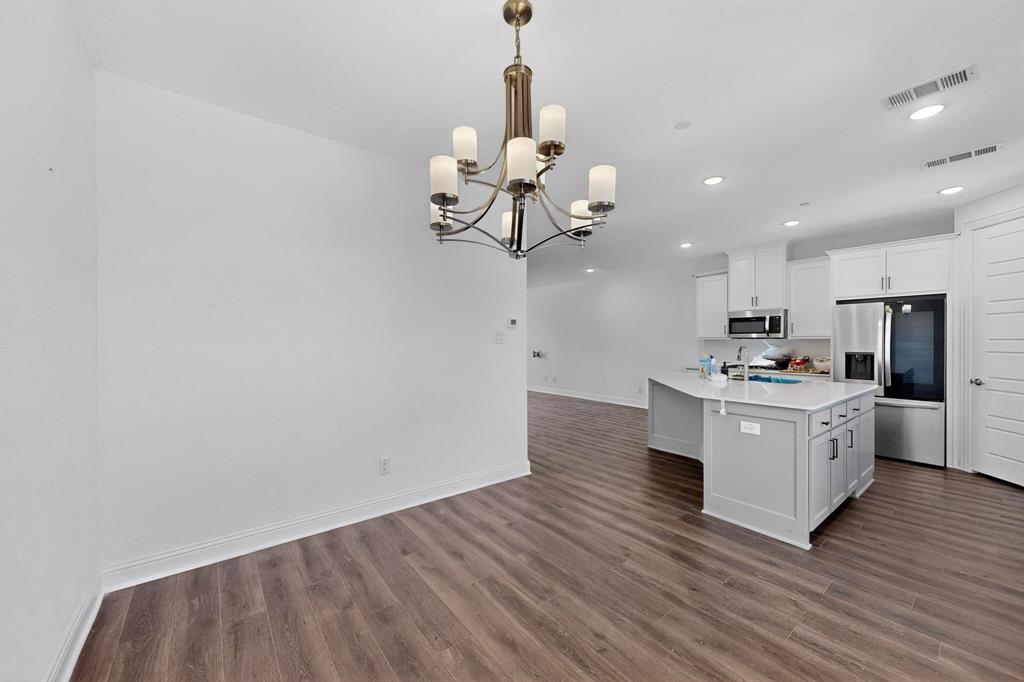 6629 Kort Street Rowlett, TX 75089 - Photo 13 of 39 a kitchen with stainless steel appliances granite countertop a white cabinets a stove top oven and chandelier