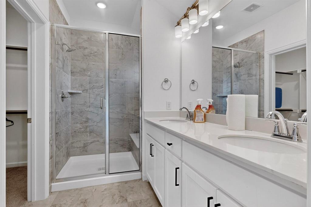 6629 Kort Street Rowlett, TX 75089 - Photo 18 of 39 a bathroom with a shower sink and mirror