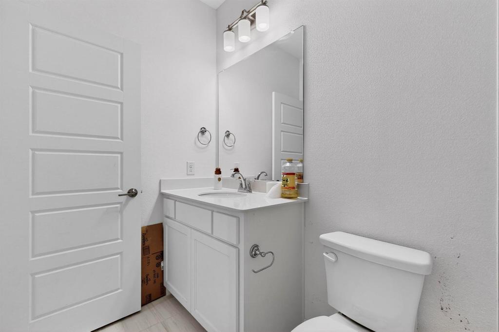 6629 Kort Street Rowlett, TX 75089 - Photo 27 of 39 a bathroom with a sink a toilet and mirror