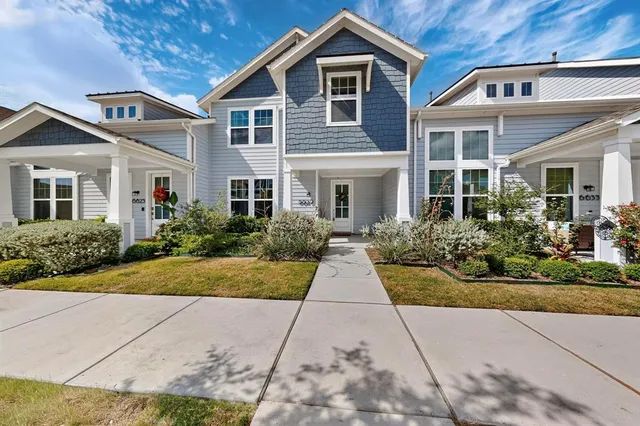 a front view of a house with yard and green space