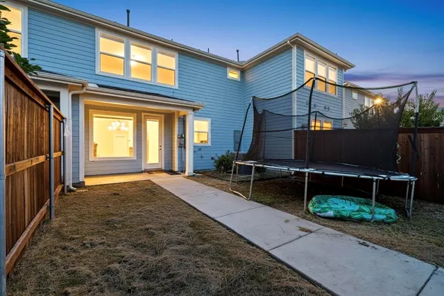 a backyard of a house with table and chairs