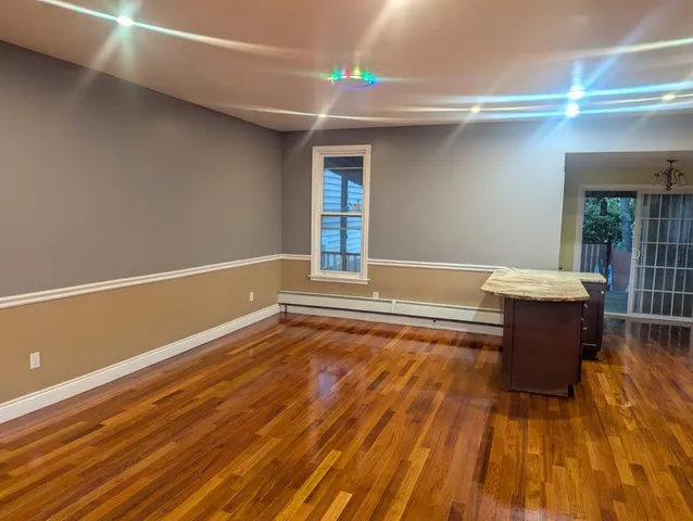 a room with wooden floor and potted plant