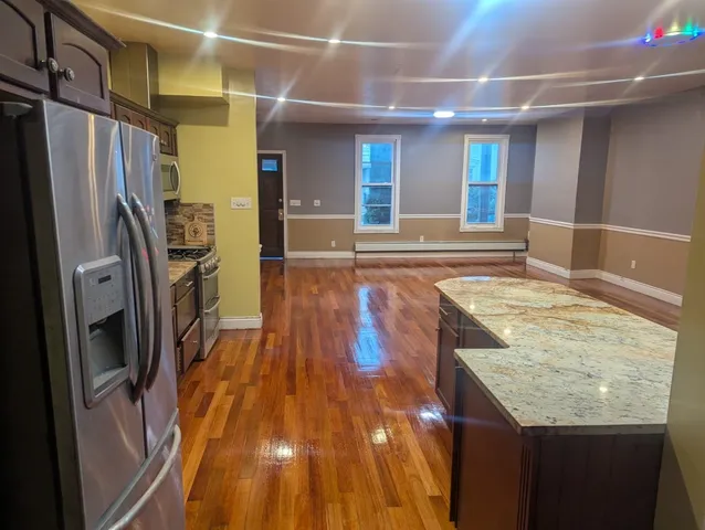 a view of a kitchen with stainless steel appliances granite countertop a refrigerator and a sink