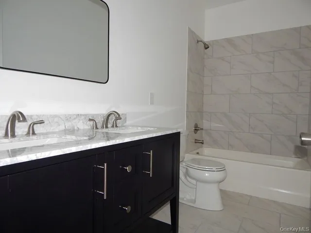 a bathroom with a granite countertop sink a toilet and bathtub