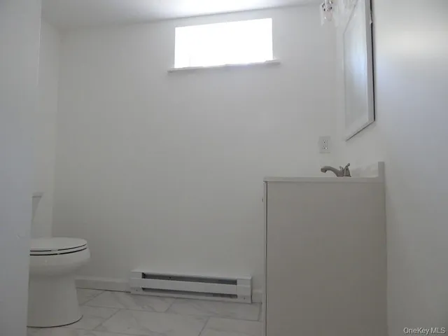 a bathroom with a granite countertop toilet and a sink