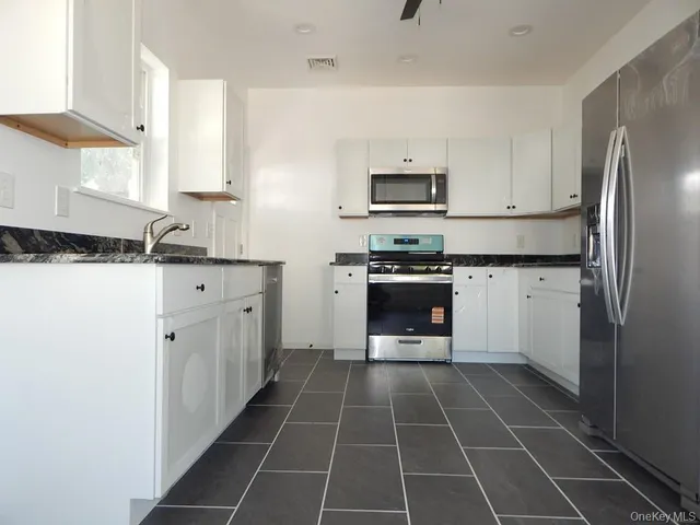 a kitchen with stainless steel appliances a sink stove and refrigerator