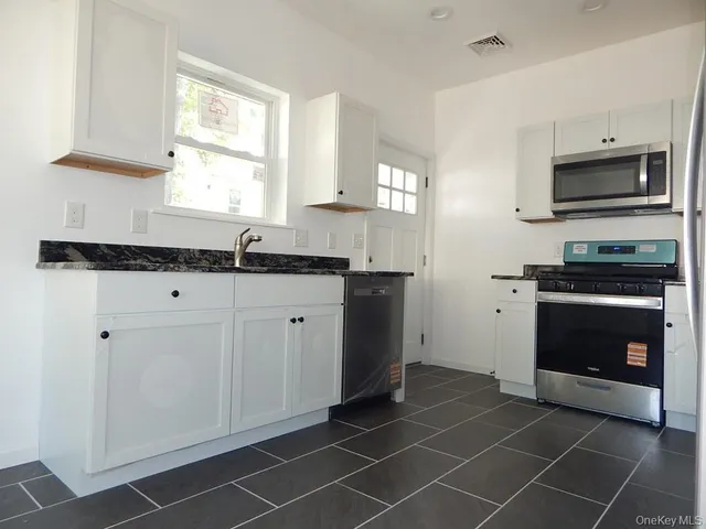 a kitchen with stainless steel appliances a sink stove and microwave