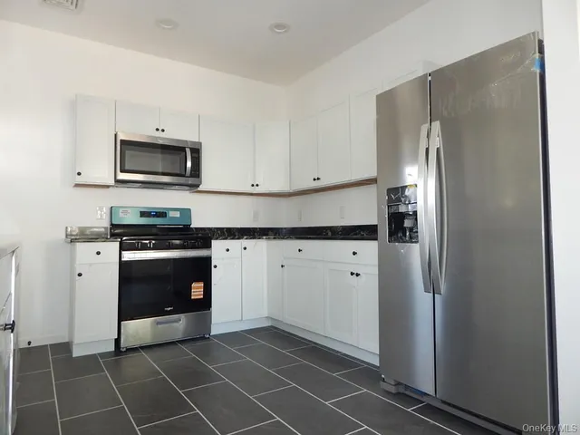 a kitchen with stainless steel appliances a refrigerator sink and microwave