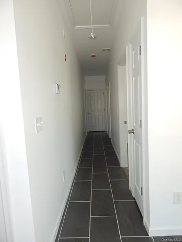 a view of a hallway with wooden floor and a window