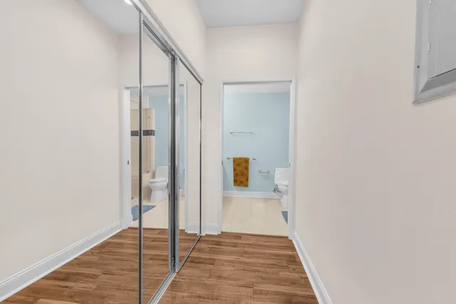 a view of a hallway with wooden floor and staircase