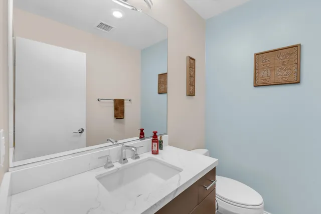 a bathroom with a sink vanity mirror and toilet