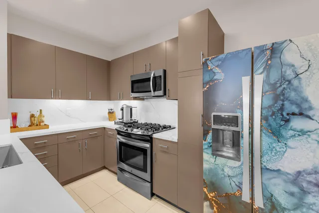 a kitchen with stainless steel appliances a stove a sink and a refrigerator