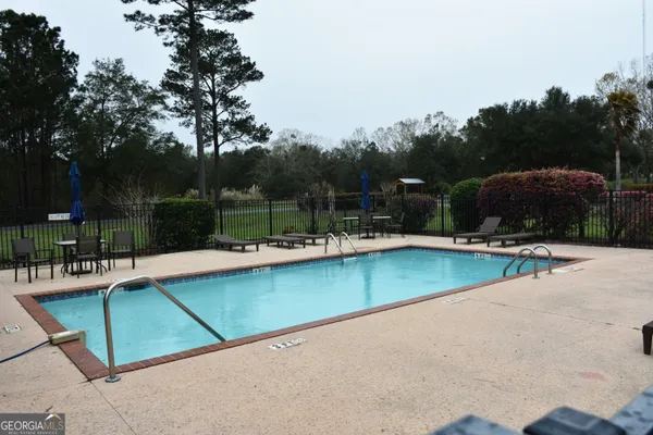 an outdoor space with swimming pool and furniture