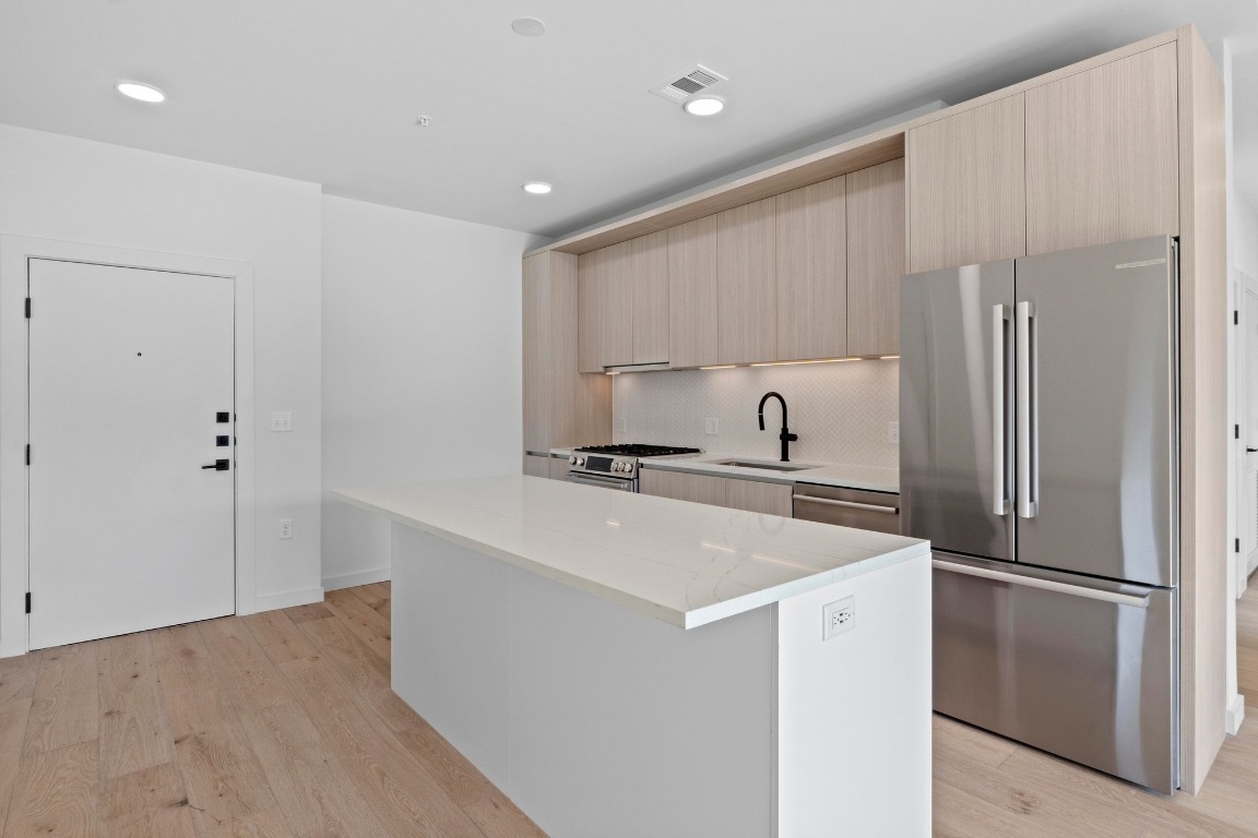 2209 South 1st Street, Unit 122 Austin, TX 78704 - Photo 11 of 40 a kitchen with stainless steel appliances a refrigerator sink and cabinets