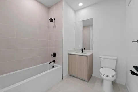 a bathroom with a toilet a sink a mirror and bathtub