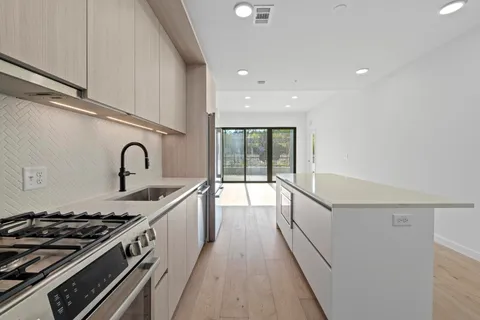 a kitchen with sink a stove and cabinets