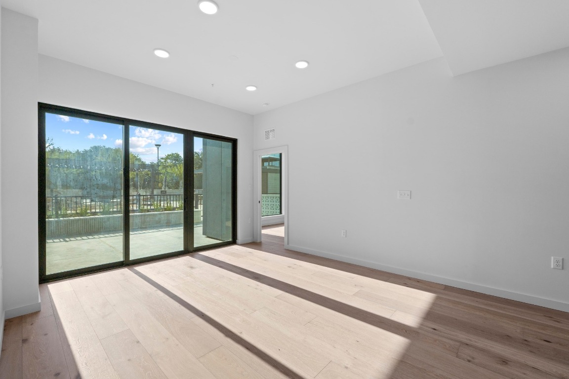 2209 South 1st Street, Unit 122 Austin, TX 78704 - Photo 6 of 40 a view of an empty room with wooden floor and a window