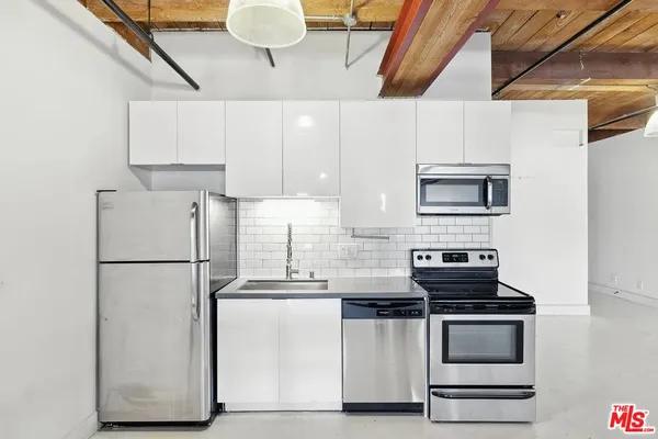 a kitchen with stainless steel appliances a refrigerator a stove a microwave and cabinets