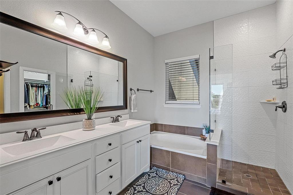 4148 Riverside Drive Flower Mound, TX 75028 - Photo 7 of 8 a bathroom with a double vanity sink large mirror and a bathtub