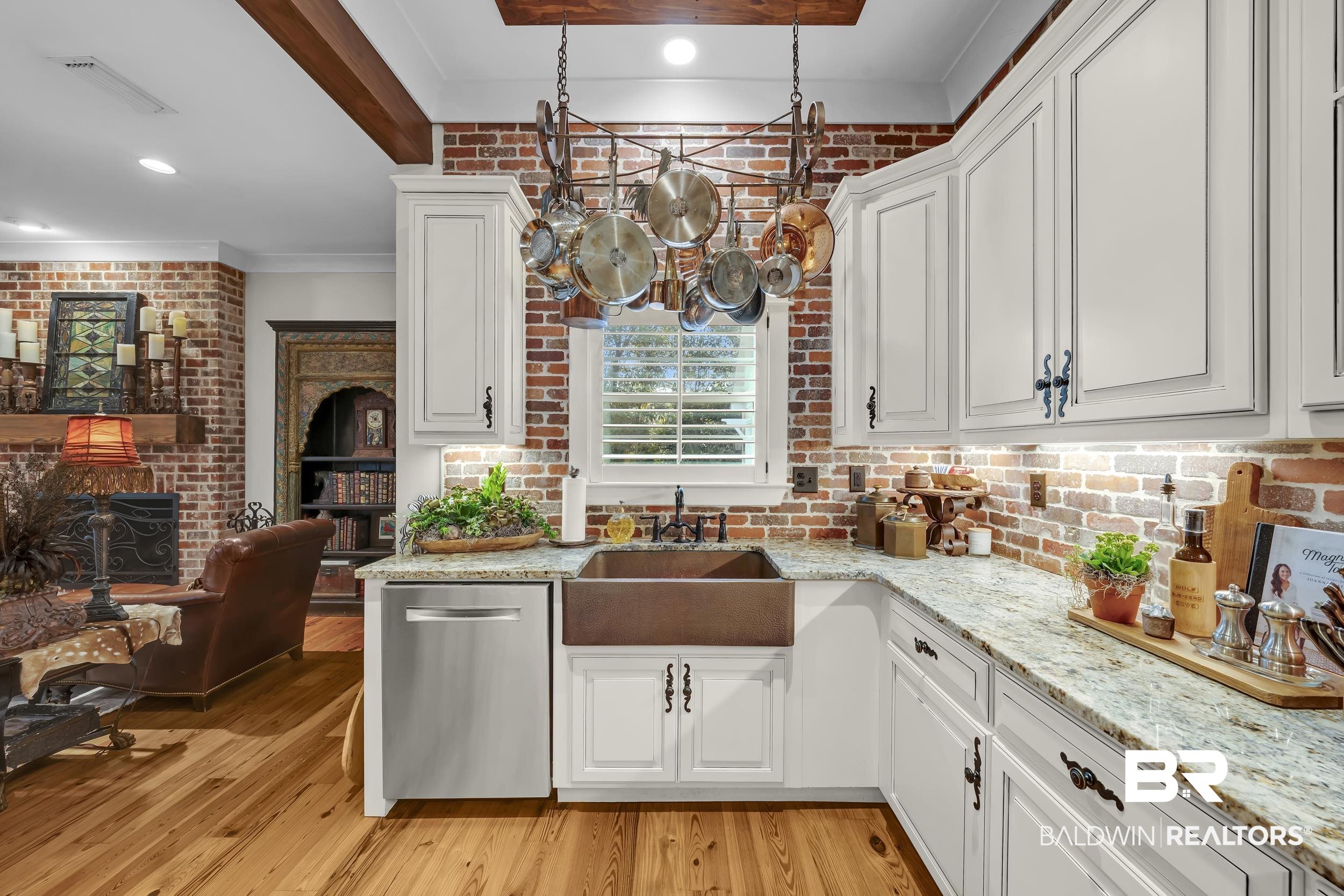 12161 Jessamine Street Magnolia Springs, AL 36555 - Photo 17 of 70 Kitchen with white cabinetry, dishwasher, light stone counters, brick wall, and crown molding