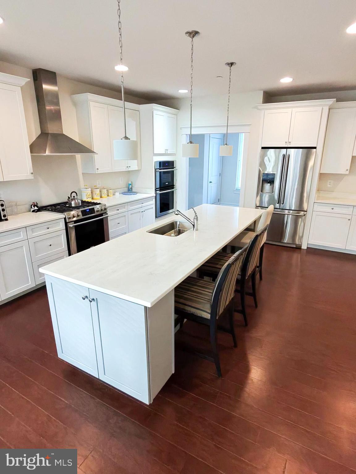 5707 Iron Stone Road Lothian, MD 20711 - Photo 9 of 90 a kitchen with a wooden floor and white appliances