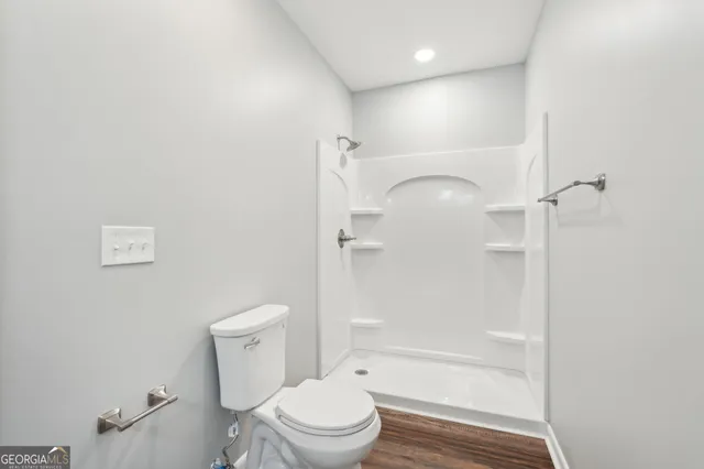 a bathroom with a granite countertop sink a toilet and a mirror