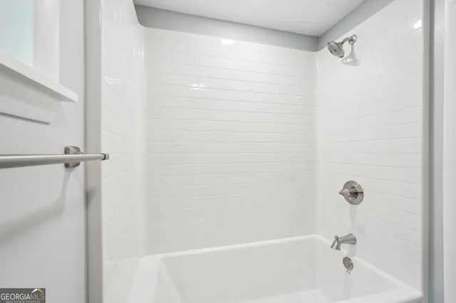 a bathroom with a granite countertop sink and white cabinets