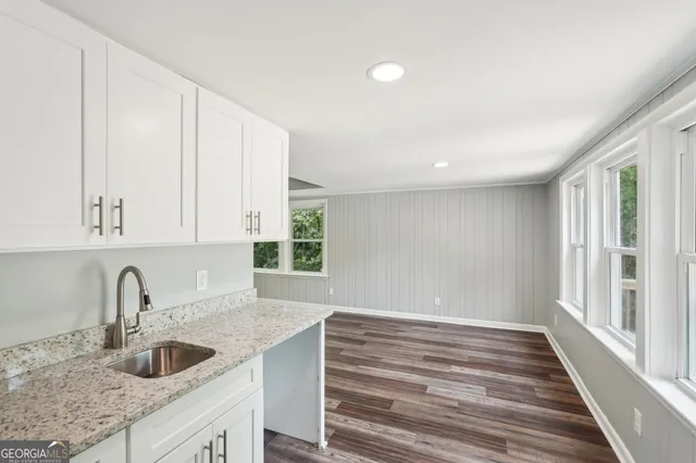 a kitchen with white cabinets and sink