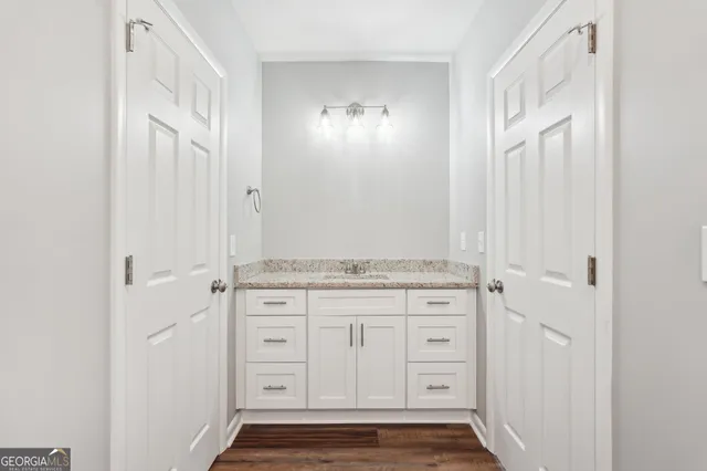 a bathroom with a granite countertop sink a toilet and a mirror