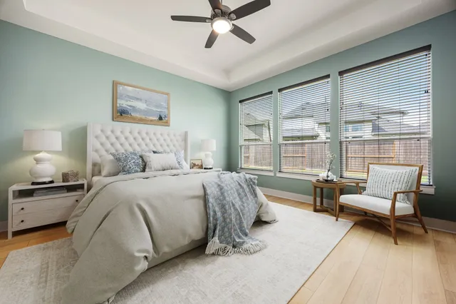 a spacious bedroom with a bed a couch and a window