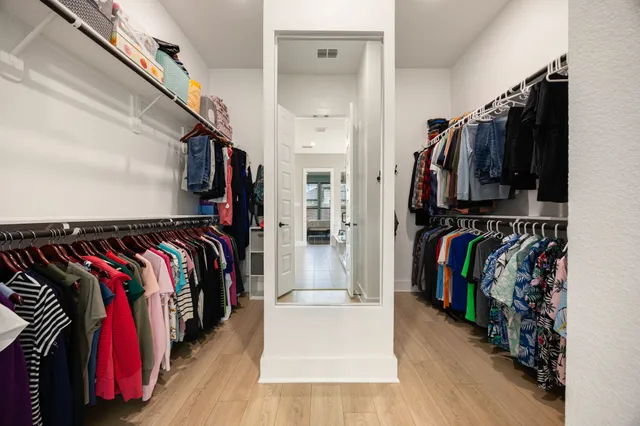 a view of walk in closet with clothes and shoes