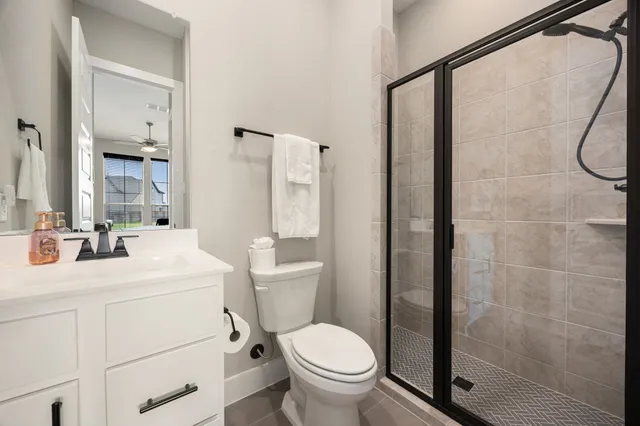 a bathroom with a sink toilet vanity and shower