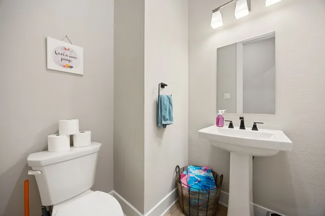 a bathroom with a sink mirror and toilet