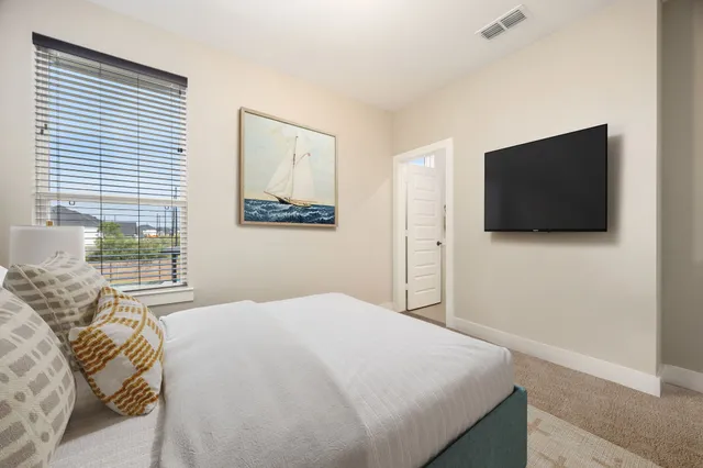 a bedroom with a bed and a flat screen tv