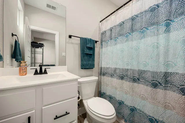 a bathroom with a sink toilet vanity and shower