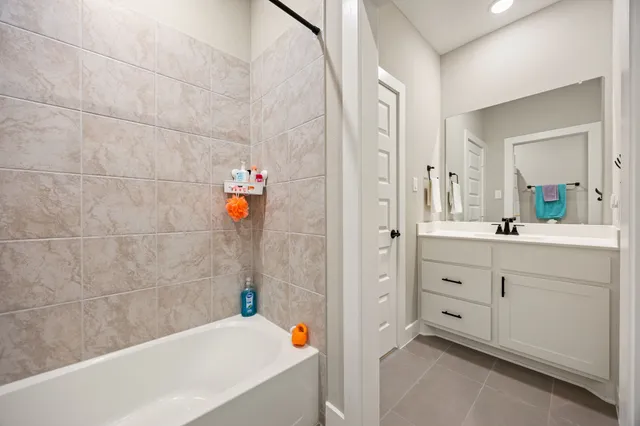 a bathroom with a tub sink and mirror