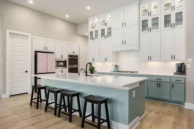 a kitchen with a table chairs microwave and cabinets