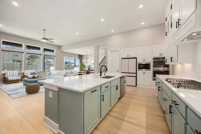 a large kitchen with stainless steel appliances lots of counter space and a sink
